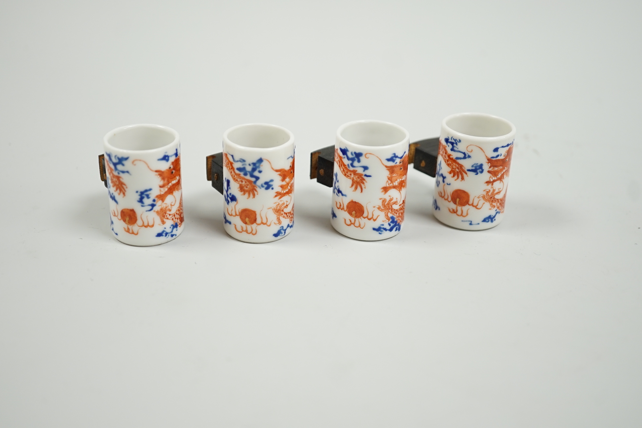 A set of four Chinese enamelled porcelain 'dragon' bird feeders, late 19th / early 20th century, 3.5cm high